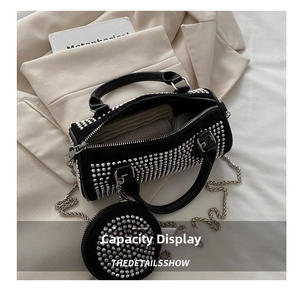 Detail of open cylindrical rivet bag interior with silver chain and small coin purse