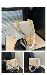 Detail of white woven flap bag featuring gold metal trim and thick chain strap