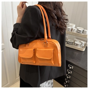 Detail view of orange shoulder bag with dual functional pockets and sleek PU material