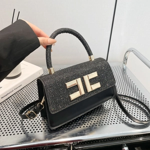 Sac à main noir élégant avec logo doré, tissu texturé et bandoulière en cuir réglable