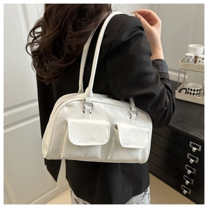 Detail of white PU leather shoulder bag with dual front flap pockets on a black blazer