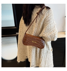 Detail of brown crocodile pattern shoulder bag with curved base and Miss mini logo