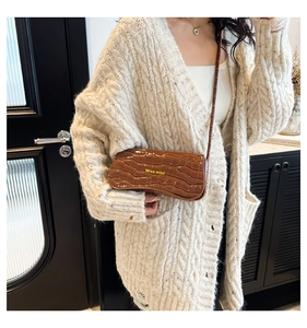 Brown crocodile pattern mini flap bag worn crossbody with Miss mini branding detail