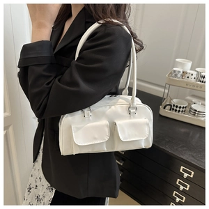 Detail of white PU shoulder bag featuring dual front pockets and sleek minimalist straps