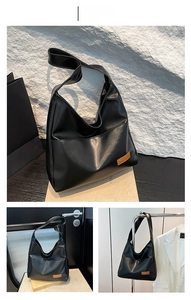 Three-way view of a black large capacity PU shoulder bag with brown leather label accent