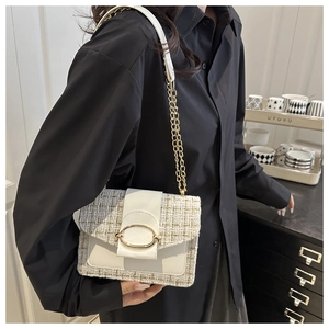 Schicke Tweed-Kettenumhängetasche in Creme, präsentiert von einem Model in modernem Ambiente