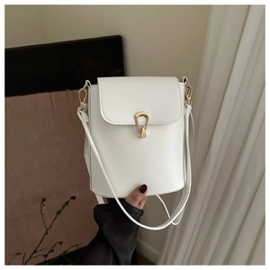 Detail of white bucket bag with gold buckle closure and smooth leather finish