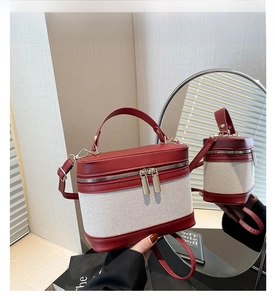 Detail of red and cream contrast stitching on vintage bucket bag with gold hardware