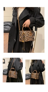 Detailed view of leopard print tote bag with brown leather handles and fringe charm