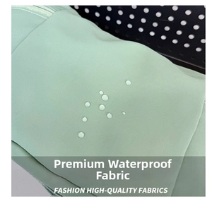 Détail macro du sac en nylon vert menthe montrant des gouttes d'eau sur le tissu imperméable