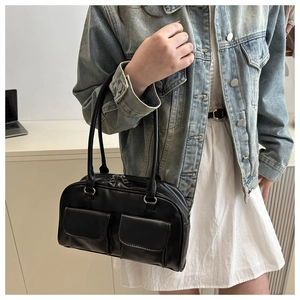 Detail of black leather underarm bag featuring dual utility flap pockets and long straps