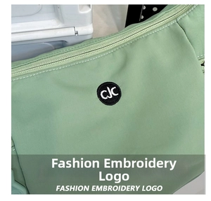 Gros plan d'un sac en nylon vert clair montrant le logo CJC brodé noir avec précision
