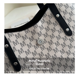 Close-up of secure silver magnetic clasp on vintage monogram letter tote bag