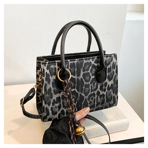 Fashionable leopard print handbag with black leather handles and crossbody strap