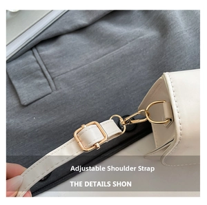 Detail of adjustable shoulder strap with gold metal buckle on white faux leather bag