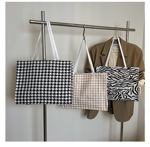 Close-up of zebra pattern and houndstooth canvas tote bags hanging on a display rack