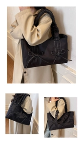 Detail of black nylon tote bag featuring ruffled straps and decorative bow accents
