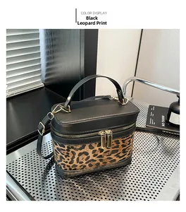 Detail of leopard print canvas bucket bag with black leather trim and gold hardware