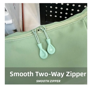 Détail de la double fermeture éclair fluide sur un sac banane en nylon vert clair