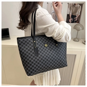 Detail der schwarzen Shopper-Tasche mit grauem M-Muster und Gold-Logo