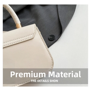 Detail of cream white small handbag showing fine stitching and gold metal hardware