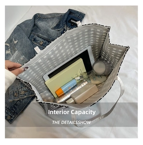 Macro detail of spacious interior in houndstooth tote bag filled with daily essentials