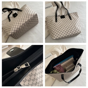 Detail view of large tote bag with letter M pattern, metal zipper and spacious interior