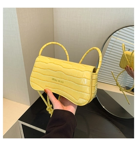 Detail of yellow crocodile pattern handbag with Miss mini logo and slim handles