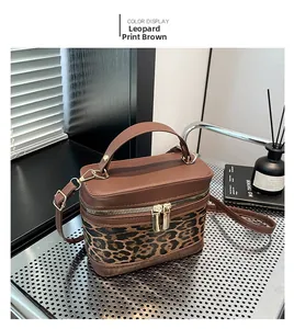 Detail of leopard print coffee leather vanity bag with top handle and gold zipper