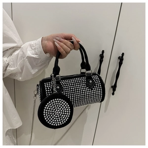 Close-up of black cylinder bag with sparkling rhinestones and matching round coin purse