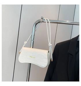 Detail of white crocodile embossed shoulder bag with gold Miss mini lettering and knot strap