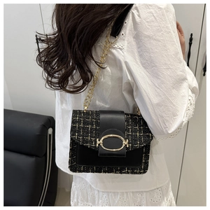 Detailansicht der schwarzen Tweed-Umhängetasche mit goldener Kette an einem Model