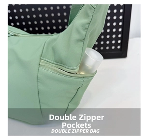 Détail de la poche zippée latérale avec rangement pour bouteille sur le sac nylon vert