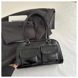 Close-up of black matte leather underarm bag featuring two front flap pockets