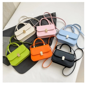 Flat lay of colorful PU leather crossbody bags in six vibrant shades with metal buckles