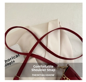 Close-up of red lychee pattern leather shoulder strap with gold metal hook buckles