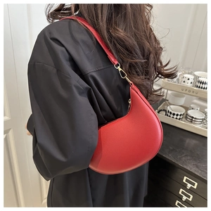 Detailansicht der roten Mondsichel-Tasche mit Lychee-Struktur und goldener Metall-Hardware