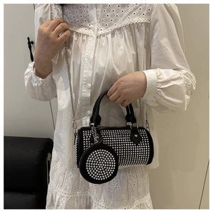 Detail of black cylinder crossbody bag with shimmering silver rhinestones and mini pouch