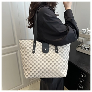 Macro shot of large tote bag with M-letter print and black shoulder strap details