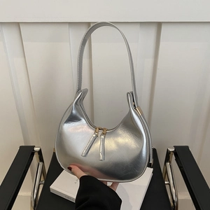 Detailed view of silver crescent underarm bag with double metallic zippers and sleek finish