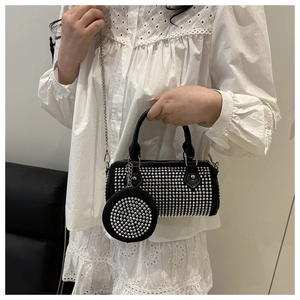 Detail of black rhinestone barrel bag with silver chain strap and small round pouch
