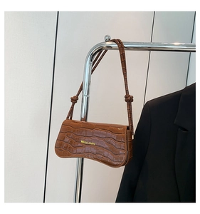 Detailed view of brown crocodile texture on shoulder bag with Miss mini lettering
