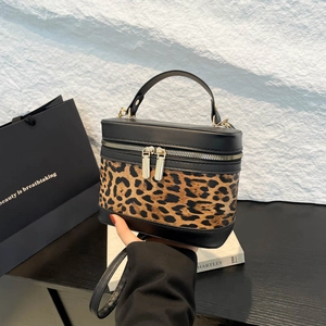 Chic leopard print and black leather handbag with gold hardware for spring 2025 fashion