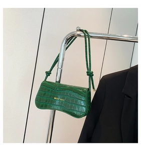 Detail of green crocodile texture on mini shoulder bag with gold Miss mini text logo