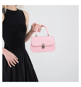 Detail of pink saddle handbag with silver twist lock and smooth synthetic leather texture