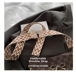 Detail of adjustable wide shoulder strap with geometric pattern and gold hardware