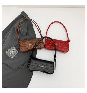Flat lay of stylish crocodile pattern shoulder bags in black, red and brown colors