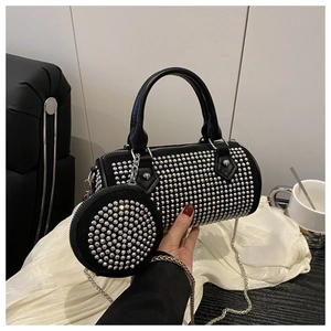 Detail of black cylinder bag with silver studs, chain strap and mini pouch