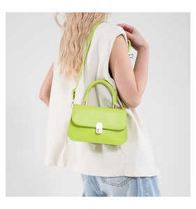Model view of a vibrant neon green underarm bag with grainy texture and metal buckle