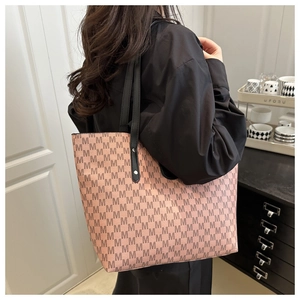 Shoulder shot of large lavender tote bag with M-pattern and black leather straps